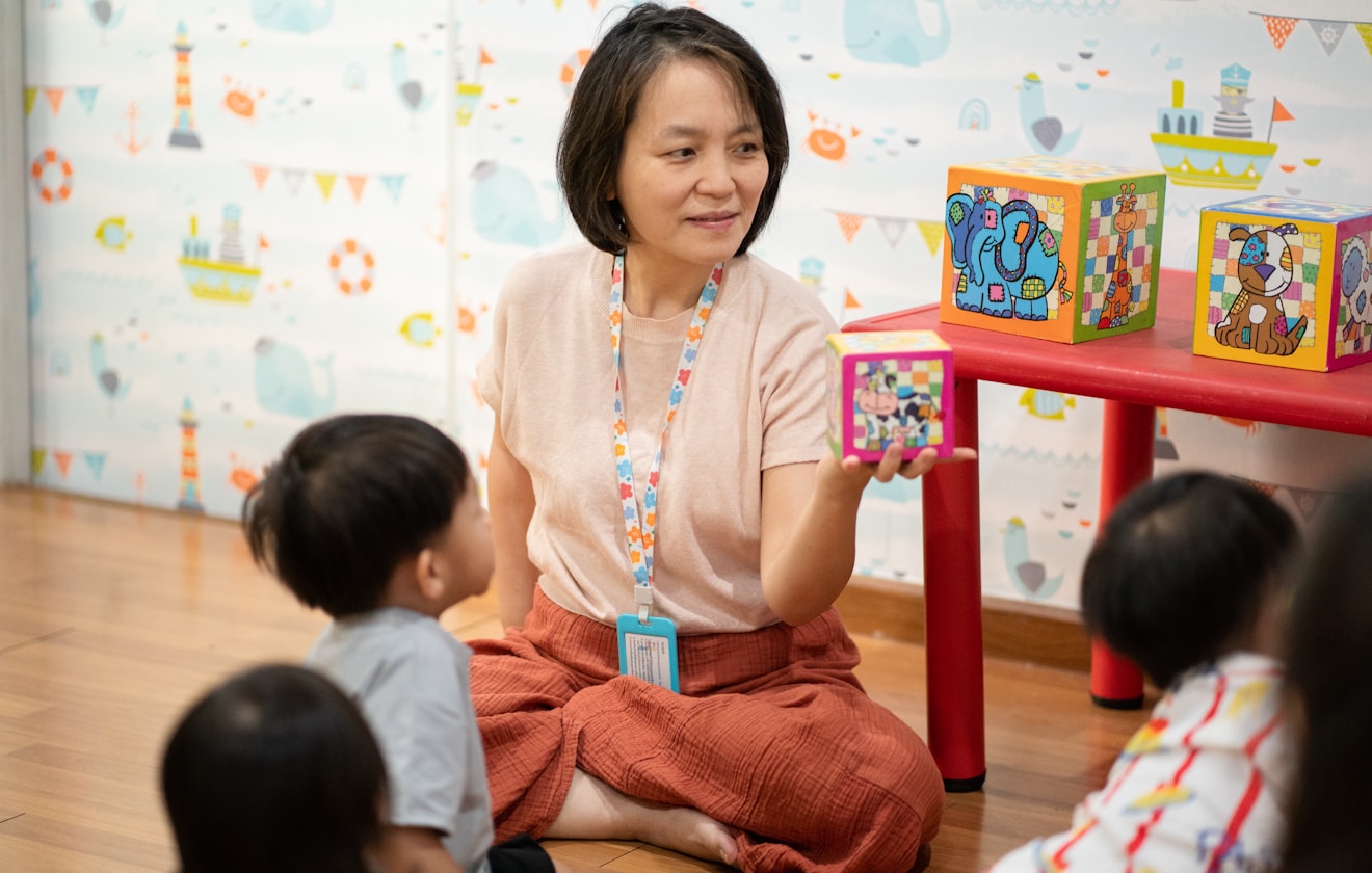 Young children exploring colourful learning materials with an educator