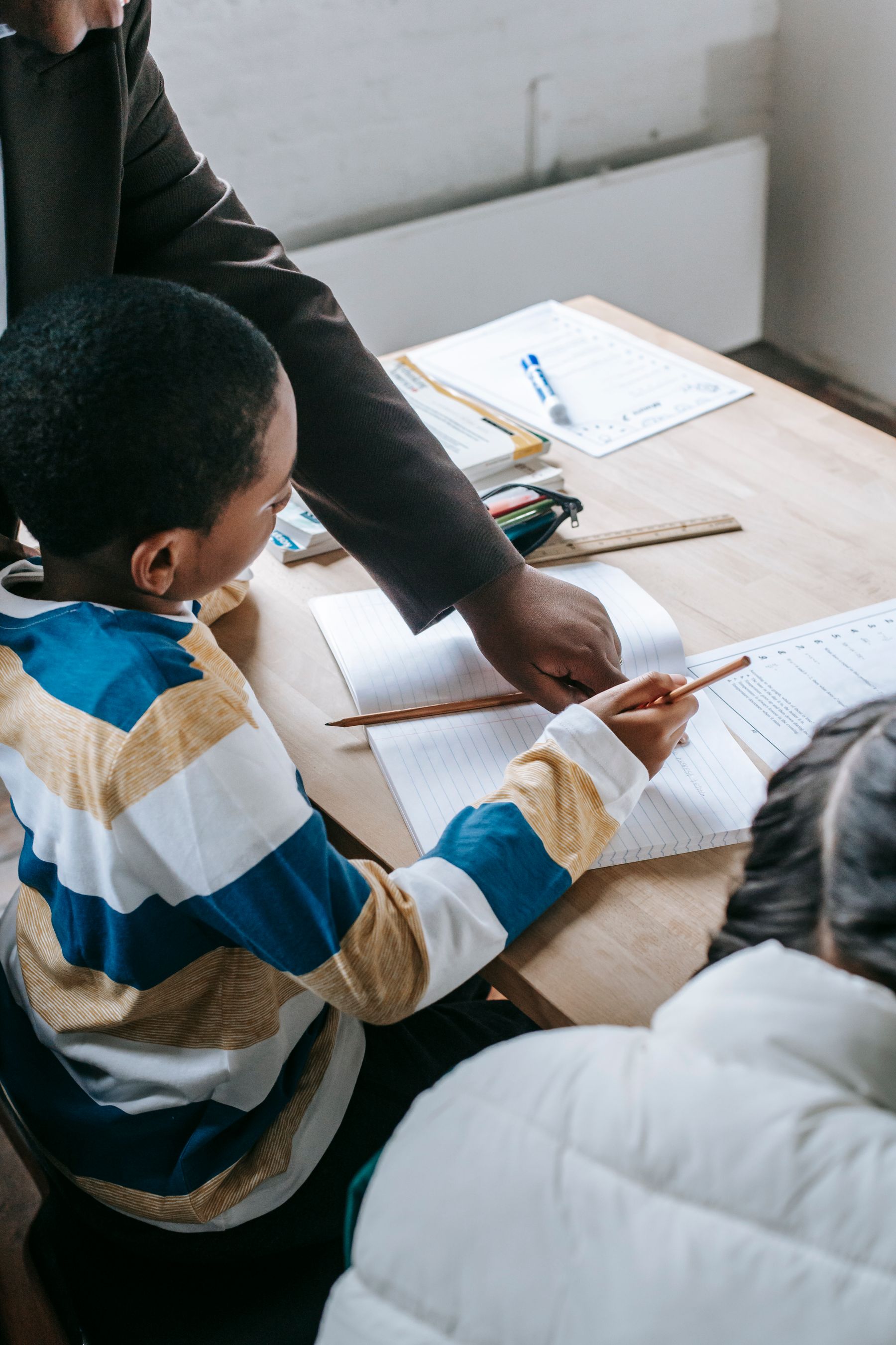 A school-age child receiving support with classroom work