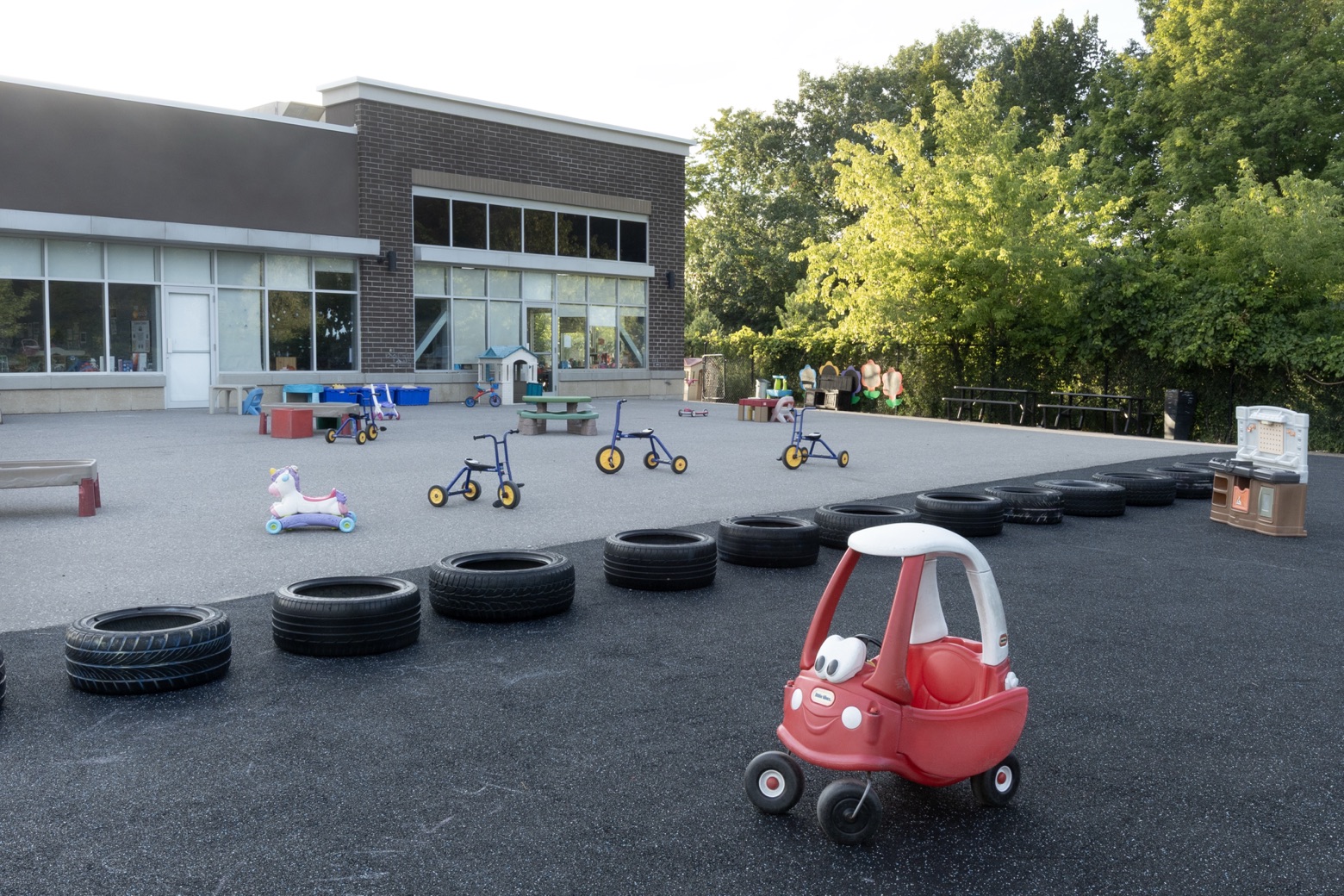 The Tender Years outdoor play yard with tire paths, tricycles and ride-on cars