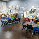 A bright Tender Years classroom with child-size tables and large windows