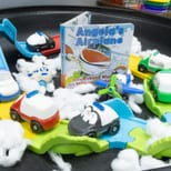 A transportation sensory tray with toy cars, ramps and cotton-ball clouds