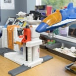A toy space shuttle and launcher beside science materials