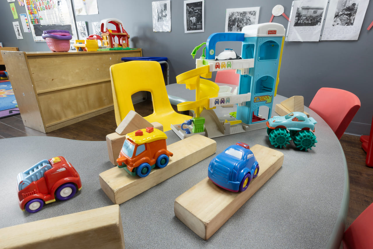 A wooden ramp and toy vehicles set up for building and testing