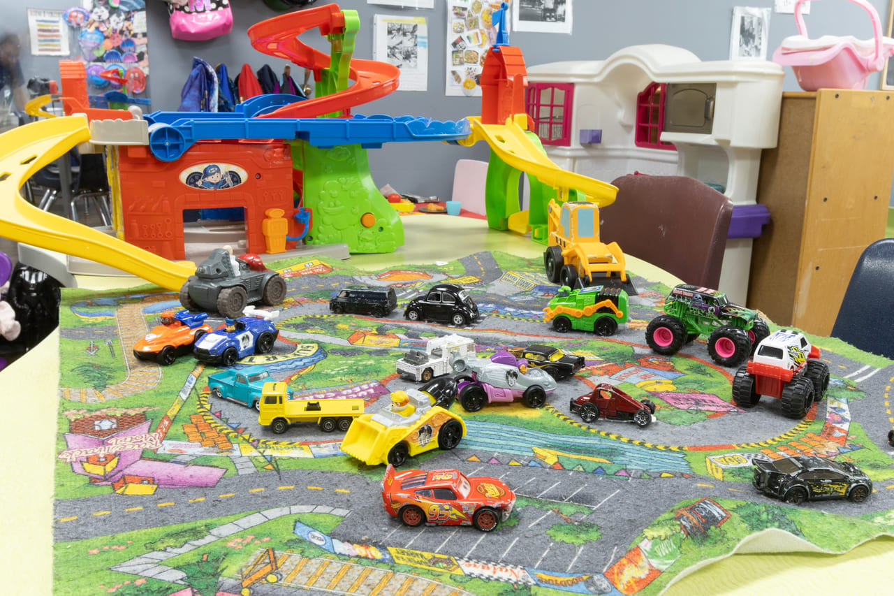 A car garage and ramp play area beside the play house