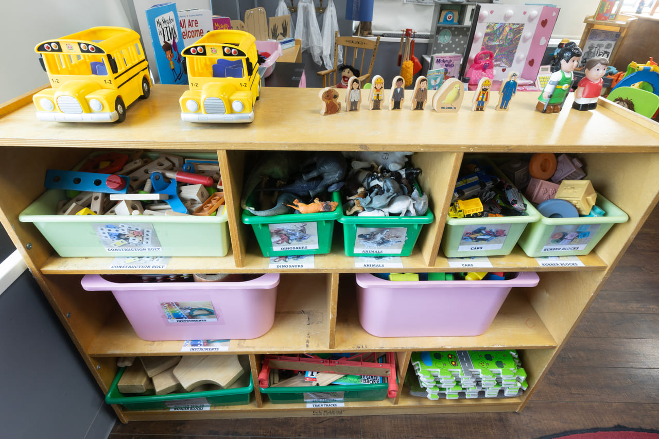 Open shelving with labelled bins of toys and materials at child height