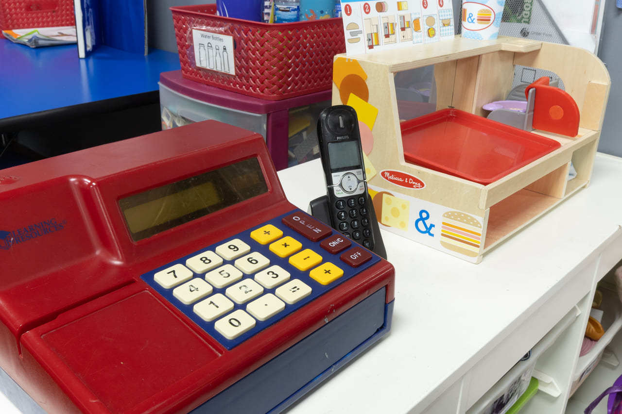 A play shop with a toy till, telephone and market stall