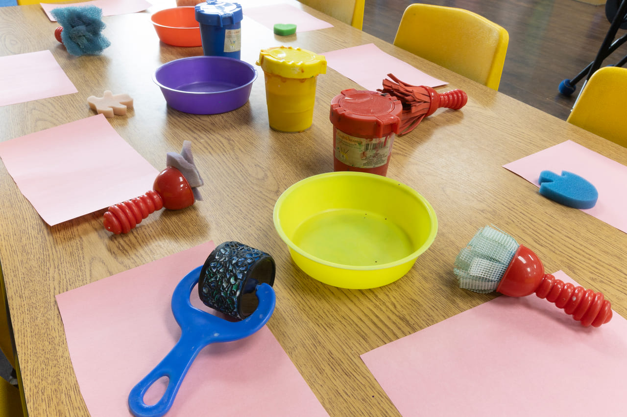 A playdough table set with rollers, cutters and bowls