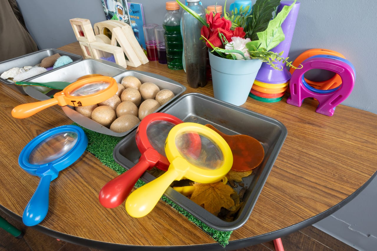 A science table set with magnifying glasses and natural materials