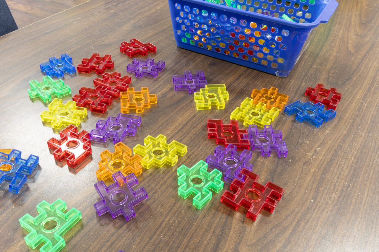 Interlocking shape blocks sorted beside a storage basket